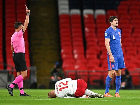 England's Harry Maguire, right, reacts as he is shown a red card.
