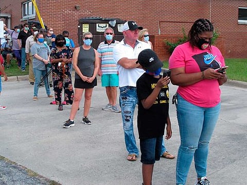 Voters wearing masks wait in line to vote early outside the Chatham County Board of Elections office in Savannah, Ga., on Wednesday, Oct. 14, 2020. 
