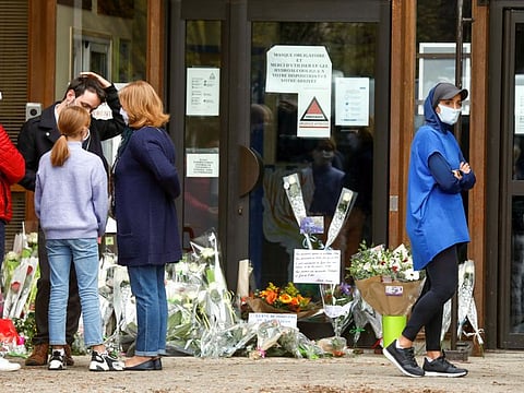 People bring flowers to the Bois d'Aulne college after the attack in the Paris suburb of Conflans St Honorine, France, October 17, 2020. 
