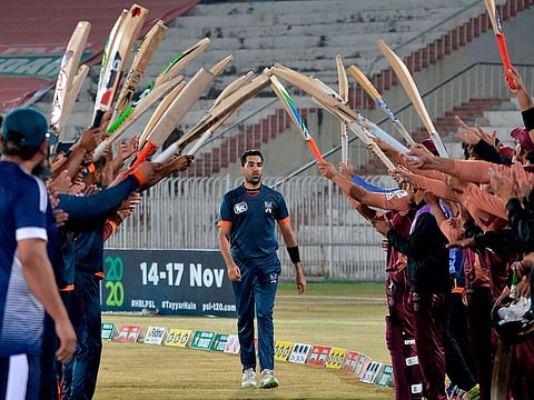 Teammates and opponents give a guard of honour to Pakistani cricketer Umar Gul during the National T20 Cup in Rawalpindi. 