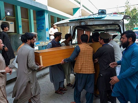 Relatives carry the coffin of a victim, who was killed in a stampede, outside a mortuary in Jalalabad on October 21, 2020