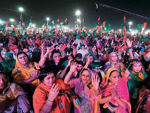 Female supporters of Pakistan Democratic Movement, an alliance of political opposition parties, react to party songs during an anti-government protest rally in Karachi.