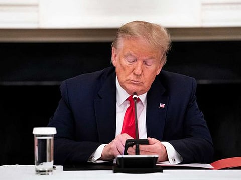 President Donald Trump types on his mobile phone, as he hosts a roundtable with governors on the reopening of America’s small businesses in the wake of the coronavirus pandemic, at the White House in Washington, Thursday, June 18, 2020. Trump is behind in many swing-state polls, but his social media accounts are attracting as much attention as ever. 
