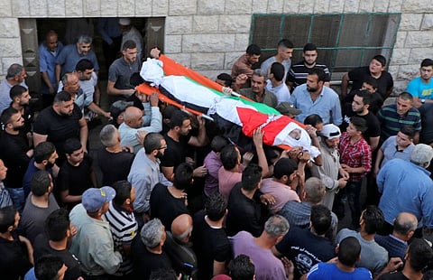 Palestinian mourners carry the body of 18-year-old Amer Snobar, who died following a confrontation with Israeli troops, during his funeral in the village of Yatma in the occupied West Bank on October 25, 2020.