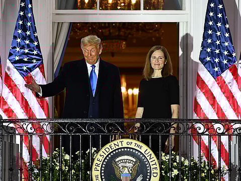US President Donald Trump gestures next to Judge Amy Coney Barrett after she was sworn in as a US Supreme Court Associate Justice during a ceremony on the South Lawn of the White House October 26, 2020, in Washington, DC.