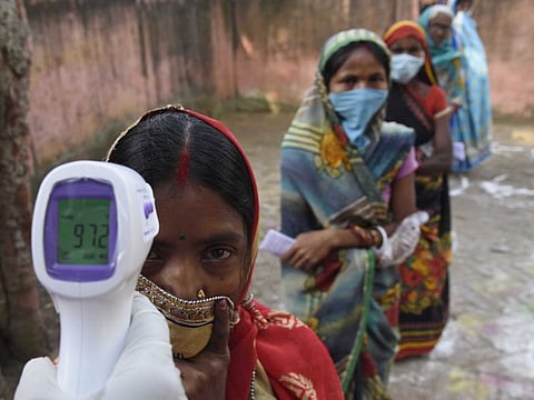 Patna: Voters undergo thermal screening before casting their vote for the first phase Bihar Assembly polls, at Paligang in Patna district on Wednesday Oct 28,2020 