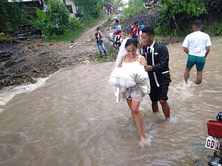 Philippines: Couple's love takes internet by storm as pictures of them braving floods to get married go viral