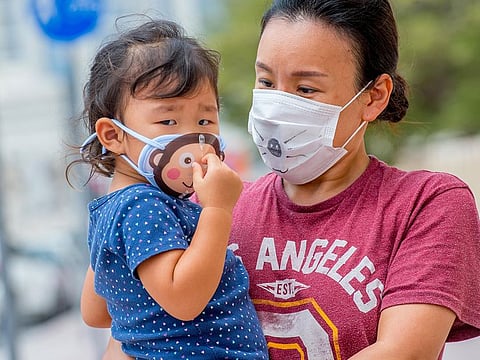A Mother walking down a street in Garhoud, with her daughter wearing funny protection mask. Dubai. Photo: Antonin Kélian Kallouche/Gulf News