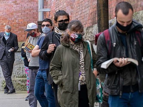 New York Mayor Bill de Blasio, left, stands in line to cast his early vote at the Park Slope Armory YMCA, Tuesday, Oct. 27, 2020, in the Brooklyn borough of New York. The mayor waited over three hours in line to cast his vote. 