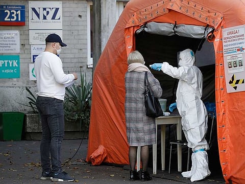 People arrive to be tested for COVID-19 in Warsaw, Poland, Thursday, Oct.22, 2020. 