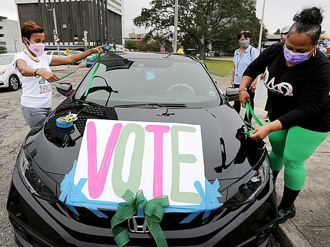 Maurya Glaude and Angela Davis decorate a car before a "Parade to the Polls" event, organized by Operation Go Vote!, a collaborative of African American civic and social organizations, in New Orleans, Saturday, Oct. 24, 2020. 