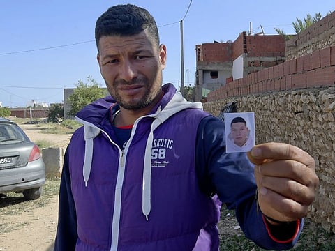 Yasin, the brother of the Nice assailant Brahim Aouissaoui, who a day earlier killed three people and wounded several others in the southern French city of Nice, shows his picture in front of the family home in the Tunisian city of Sfax, on October 30, 2020. 