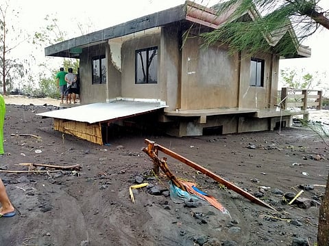 Residents stand on the roof of their house after a river overflowed due to heavy rains brought about by super Typhoon Goni, inundating houses in Daraga, Albay province, south of Manila. Handout photo taken on November 1, 2020 from Alejandro Miraflor’s Facebook page