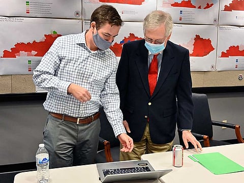Republican Senate candidate Sen. Mitch McConnell, right, talks with a staff member as they watch the results of his reelection bid in Louisville, Ky., Tuesday, Nov. 3, 2020. 
