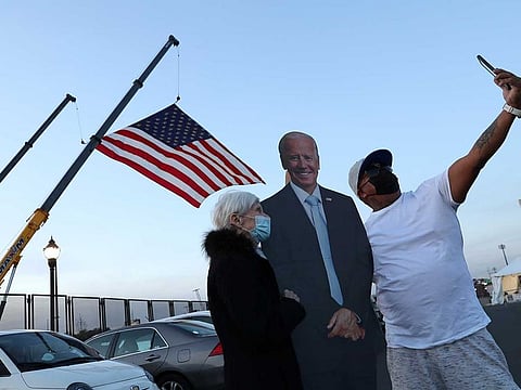 Supporters including Jo Lawlor of Pennsylvania (L) pose for photographs with a cutout of former Vice President Joe Biden near the site where Biden and Senator Kamala Harris hope to celebrate their victory in the U.S. presidential race in Wilmington, Delaware, U.S., November 5, 2020.