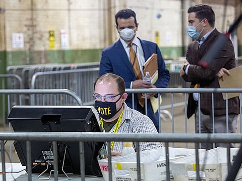 Observers watch a poll worker tabulate ballots at the Allegheny County Election Warehouse after the election in Pittsburgh, Pennsylvania.