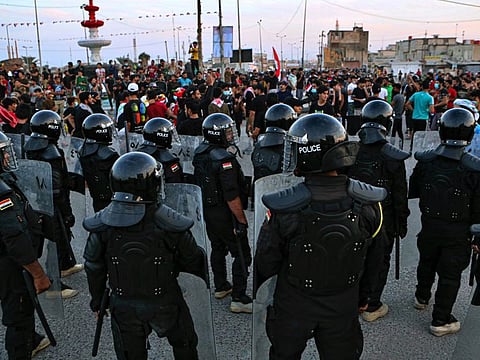 Security forces prevent anti-government protesters from setting up sit in tents in Basra, Iraq, Friday.