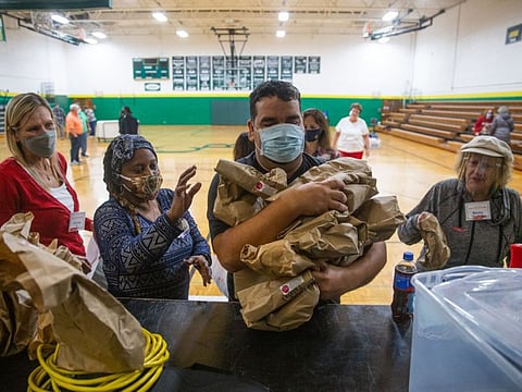 Yassin Terou, a business owner, Syrian refugee and first-time voter in the US delivers free sandwiches to people working the voting polls at Bearden Middle School in Knoxville, Tennessee on November 3, 2020. 