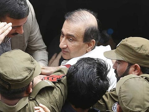 Pakistani police officers escort Mir Shakilur Rehman owner of Jang Group of Newspapers to an anti-graft court in Lahore, Pakistan, Friday, March 13, 2020. 
