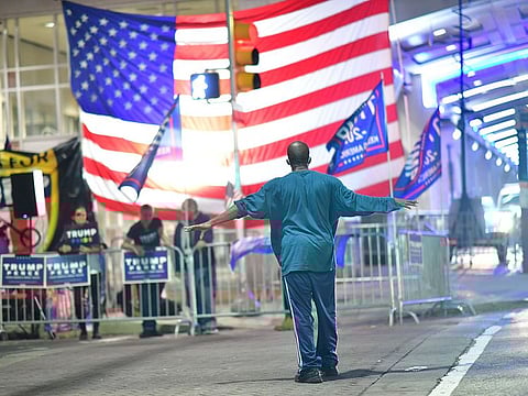 A man approaches supporters of President Donald Trump demonstrating outside of where votes are still being counted six days after the general election on November 9, 2020 in Philadelphia, Pennsylvania, United States. 