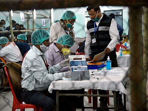 Election officers wearing face masks count votes for the Bihar state assembly polls, at a counting centre in Patna, India, Tuesday, Nov. 10, 2020. 