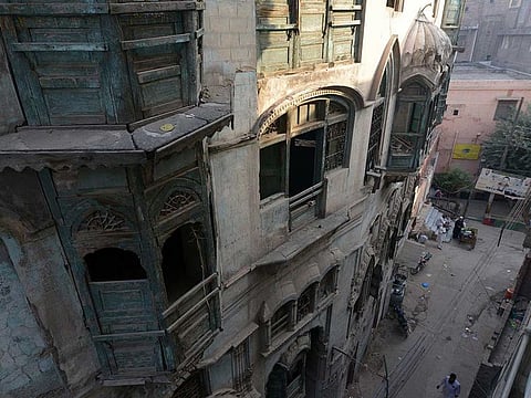 In this picture taken on October 7, 2020, residents walk in front of the Kapoor mansion, the more than 100-year-old ancestral home of late Indian Bollywood icon Raj Kapoor in Peshawar, which authorities in Pakistan's northwestern Khyber Pakhtunkhwa province plan to restore and turn into a museum.