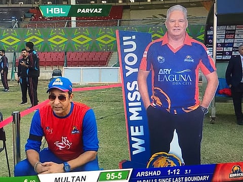 A giant cutout of Dean Jones, the departed head coach of Karachi Kings, keeps a watch as their mentor Wasim Akram is in a reflective mood in Karachi on Saturday.