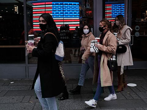 People walk through Times Square as New York City tries to contain a spike in COVID-19 cases.