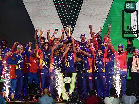 Karachi Kings team members and support staff celebrate with the PSL winners' trophy in Karachi on Tuesday evening. 