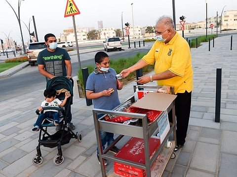 Pakistani expatriate Mohammad Dawood  serving free water, biscuits, sanitisers and disposable prayer mats to visitors on the Sharjah beach near his house.