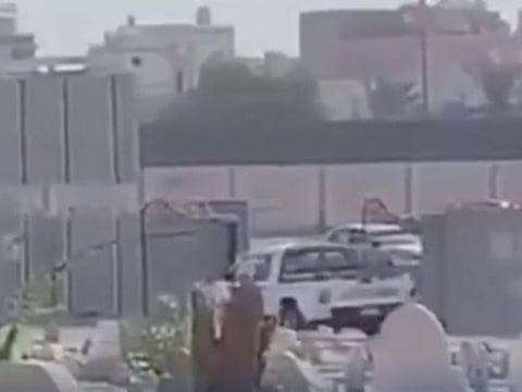 The men exit the cemetery in a screengrab from the viral video.