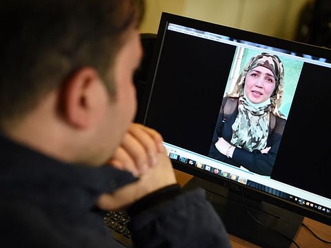 In this picture taken on November 12, 2020, a man watches a video of Afghan woman Muzghan, who walked free from jail in September after confessing to being members of the Taliban's ultra-violent Haqqani network, on a computer screen in Kabul. 