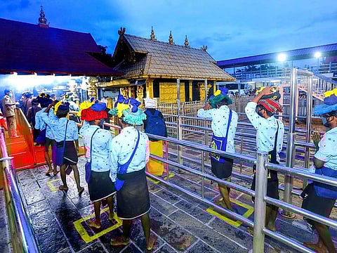 Devotees stand in queues to offer prayers at Ayyappa temple on the at Sabarimala in Pathanamthitta, Monday, Nov. 16, 2020. 