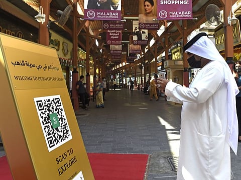 A visitor scanning the newly launched City of Gold Expolore Map QR Code kiosk at the gold souk. 