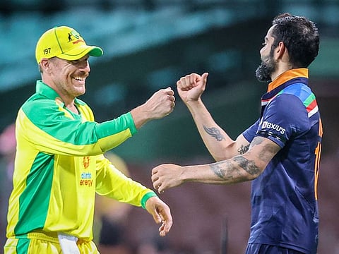Australia's David Warner and India's Virat Kohli share a joke during the first ODI