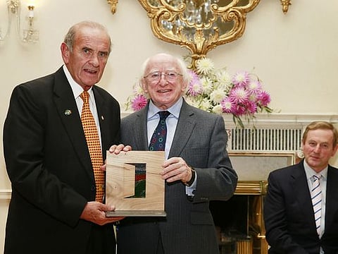 Colm McLoughlin accepting the Irish Presidential Distinguised Service Award from the Irish President, Michael D Higgins while An Taoiseach Enda Kenny looks on.