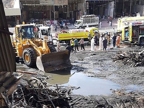 Debris being removed from the site of the fire at the Friday Market in Masafi.