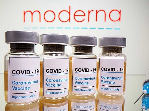 Illustrative image: Vials with a sticker reading, "COVID-19 / Coronavirus vaccine / Injection only" and a medical syringe are seen in front of a displayed Moderna logo in this illustration taken October 31, 2020. 