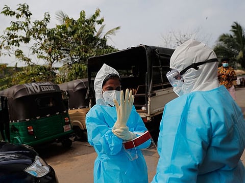 Sri Lankan health officials prepare to collect swab samples to test for COVID-19 in Colombo, Sri Lanka, Monday, Nov. 23, 2020.