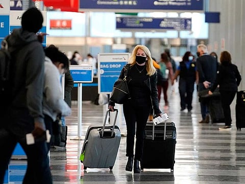 A traveller wears a mask as she walks through Terminal 3 at O'Hare International Airport in Chicago, Sunday, Nov. 29, 2020. 