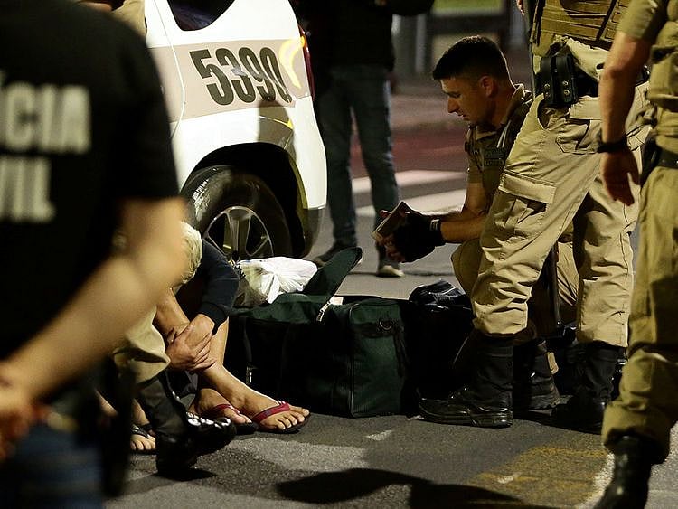 A police officer checks a recovered bag with money