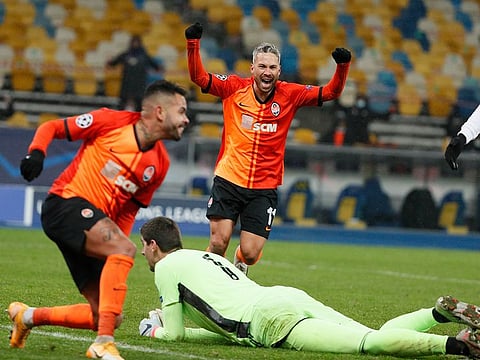 Real Madrid's Thibaut Courtois looks dejected as Shakhtar Donetsk's Marlos celebrates their first goal.