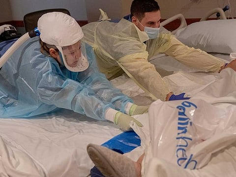 John Deaton, a travelling nurse, works with other medical staff to transport an 89-year-old COVID-19 patient at Bellin Hospital in Green Bay, Wis., on Nov. 23, 2020. As the coronavirus has spiked across the country, with hospitalisations high in both urban and rural areas, travel nurses — who work on temporary contracts for higher fees — are helping to fill the void. 