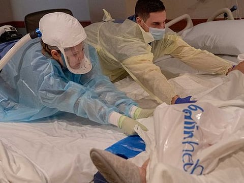 John Deaton, a travelling nurse, works with other medical staff to transport an 89-year-old COVID-19 patient at Bellin Hospital in Green Bay, Wis., on Nov. 23, 2020. As the coronavirus has spiked across the country, with hospitalisations high in both urban and rural areas, travel nurses — who work on temporary contracts for higher fees — are helping to fill the void. 