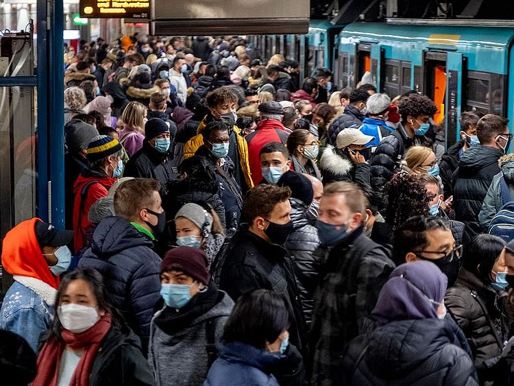 People with face masks stand close together as they wait for a subway train in Frankfurt, Germany, Wednesday, Dec. 2, 2020.