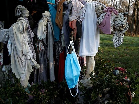 A protective mask hangs from "L'arbre à loques", a "healing" tree to which people attach cloths as a ritual for good health according to Celtic tradition, during the coronavirus diesease (COVID-19) pandemic in Hasnon, France December 6, 2020.