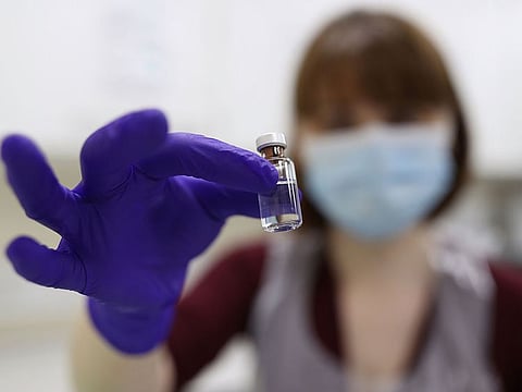 An NHS pharmacy technician holds a vial as she simulates the preparation of the Pfizer-BioNTech COVID-19 vaccine, during a staff training session ahead of the vaccine's rollout next week, at the Royal Free Hospital in London.