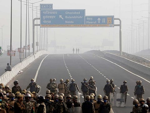 Police officers stand guard at the site of a protest on an empty blocked highway during a nationwide strike against the newly passed farm bills at the Delhi-Uttar Pradesh border in Ghaziabad, India, December 8, 2020. 