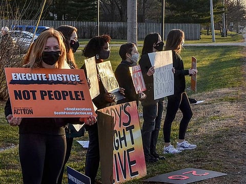 Protesters line Prairieton Road across from the Federal Execution Chamber, Thursday, Dec. 10, 2020 in Terre Haute, Ind. against the execution of Brandon Bernard, convicted in the 1999 killing of two youth ministers in Texas. 
