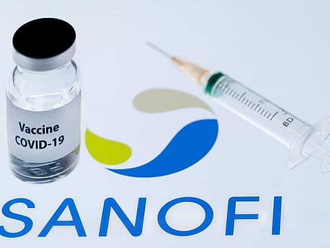 This file photo taken on November 23, 2020 shows a bottle reading "Vaccine Covid-19" next to French biopharmaceutical company Sanofi logo. France's Sanofi and Britain's GSK said on December 11, 2020 that their Covid-19 vaccines will not be ready until the end of 2021, after interim results showed a low immune response in older adults. 